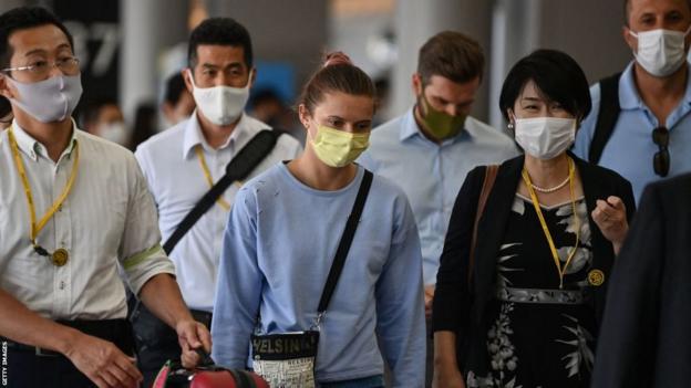 Krystsina Tsimanouskaya pose avec des responsables japonais à l'aéroport de Tokyo