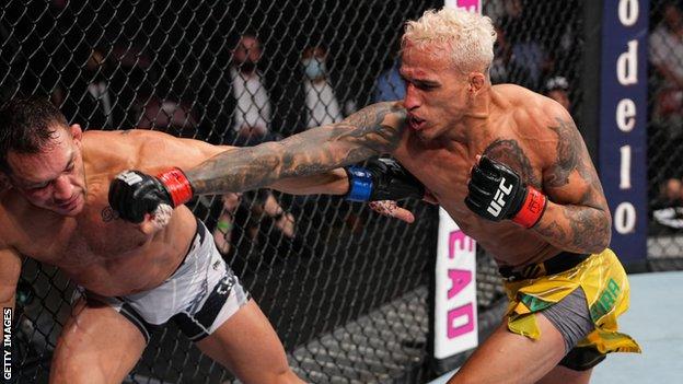 Charles Oliveira (right) hits Michael Chandler (left) on his way to winning the UFC lightweight title