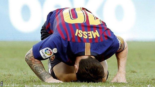 Lionel Messi looks frustrated with his head on the turf