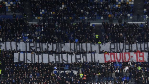 Fans display banner reading "in tragedies there is no rivalry, united against Covid-19"