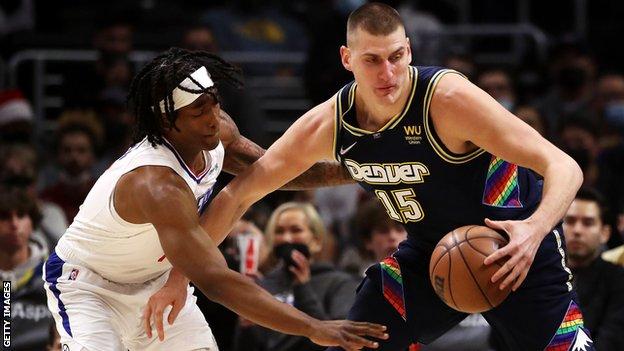 Nikola Jokic dribbles the ball away from Terance Mann