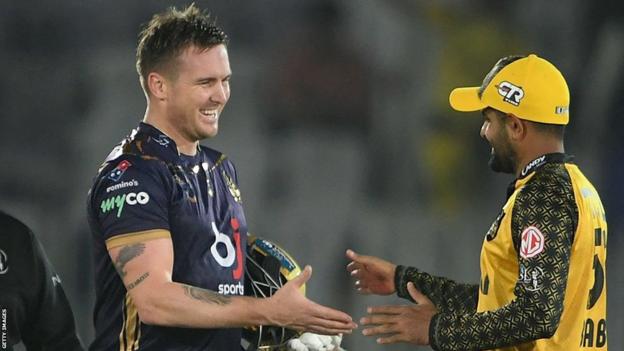 Quetta Gladiators' Jason Roy (left) shakes hands with Peshawar Zalmi's captain Babar Azam