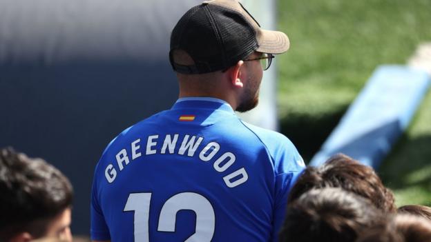 A Getafe fan wears a shirt with Greenwood's name