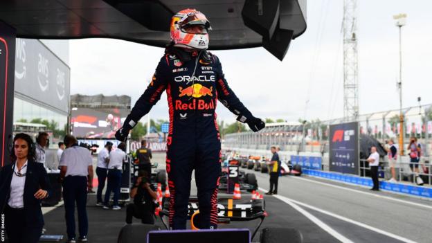 Max Verstappen stands on his car to celebrate at the end of the Spanish GP