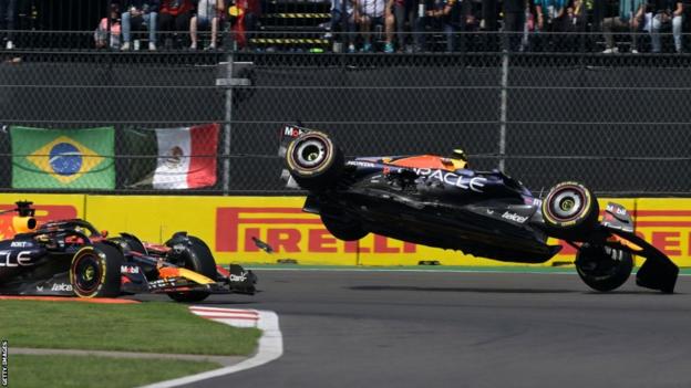 Sergio Perez's Red Bull flies through the air after colliding with Charles Leclerc's Ferrari on lap 1 of the Mexico City Grand Prix