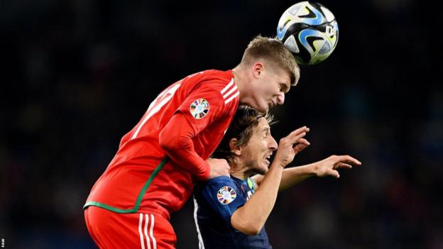 Wales' Jordan James wins a header against Croatia's Luka Modric