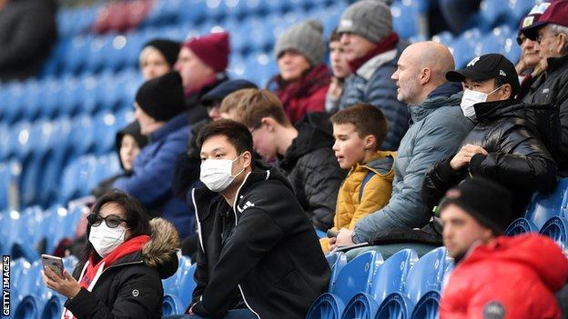 Fans wearing disposable face masks prior to the Premier League match between Burnley and Tottenham Hotspur