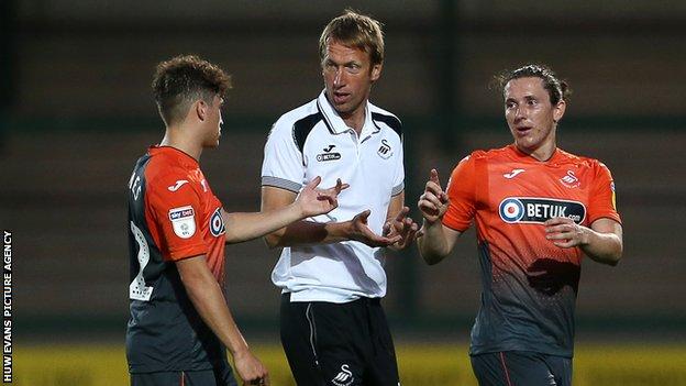 Swansea City manager Graham Potter talks to Daniel James and Aaron Lewis
