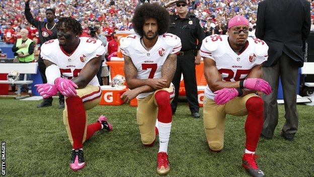 Eli Harold, Colin Kaepernick and Eric Reid kneeling in protest during the American national anthem