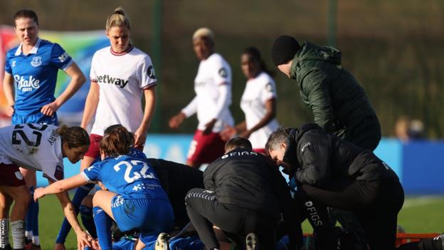 La jugadora del Everton Karoline Olesen recibe tratamiento médico tras una lesión en la pierna
