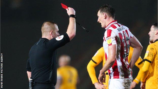 Will Boyle of Cheltenham Town is shown a red card by referee Lee Swabey after bringing down Jamille Matt