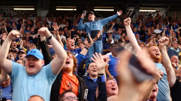 Everton fans celebrate their side staying in the Premier League