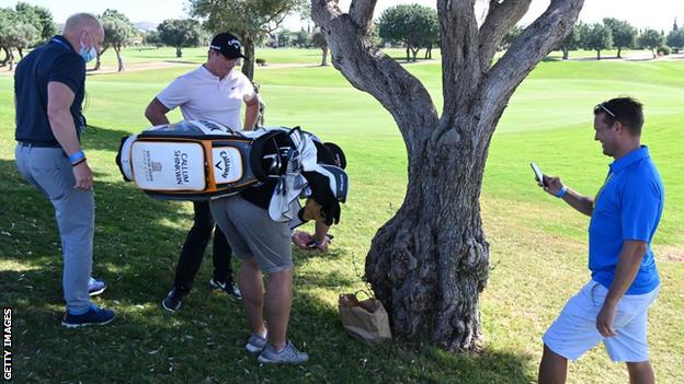 Callum Shinkwin's caddy takes a photo of the ball in the bag