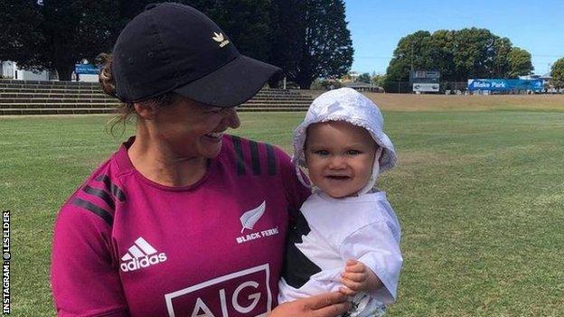 Les Elder in New Zealand kit holds her daughter and smiles