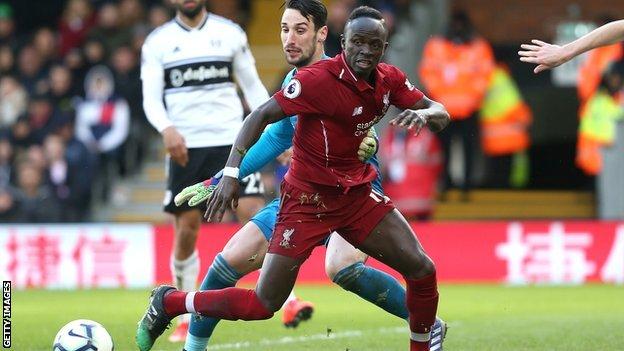 Liverpool forward Sadio Mane falls as he is fouled by Fulham keeper Sergio Rico to win a penalty