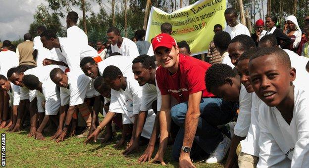ロジャー フェデラーは、2010 年 2 月 12 日にエチオピアのコレ ロバで彼の慈善団体によって資金提供された学校を訪問中に、地元の学校の子供たちとポーズをとっています。
