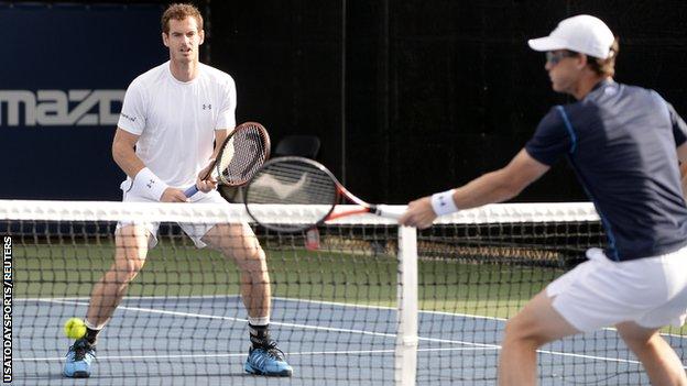 Andy Murray (left) looks on as brother Jamie plays a volley on Montreal