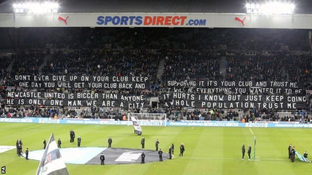 Newcastle United fans unveil a banner at their home game with Burneley