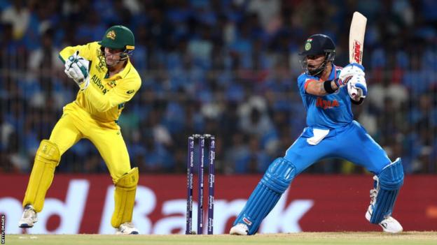 India batter Virat Kohli cuts the ball as Australia wicketkeeper Alex Carey watches on