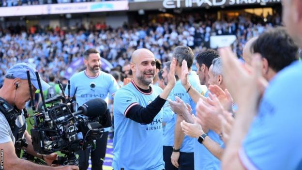 Pep Guardiola celebrates winning the 2022/23 Premier League with staff at Etihad Stadium
