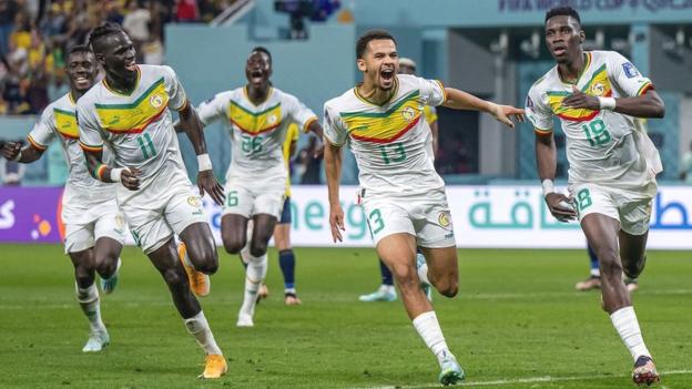 Senegalese players celebrate Ismaila Sarr's penalty strike against Ecuador