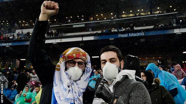 Two Real Madrid fans wearing face masks at a match against Barcelona