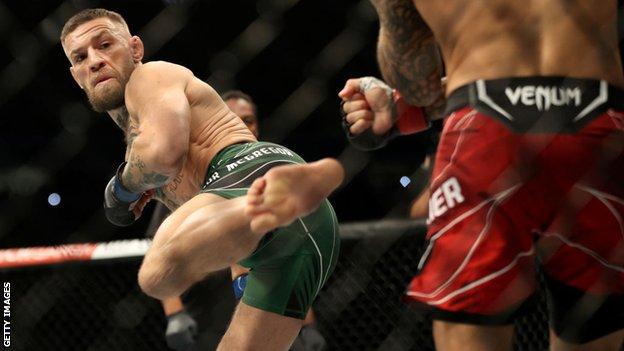 Conor McGregor aims a kick at his opponent