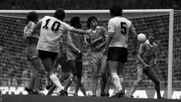 Tommy Hutchison makes his fateful attempt to block a free-kick from Glen Hoddle