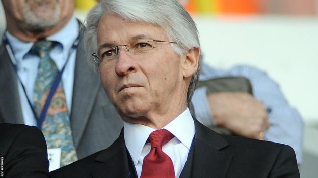 Dick Law in a suit and tie at an Arsenal match