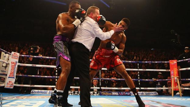 The referee steps in between Dillian Whyte and Anthony Joshua