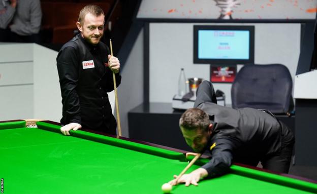 Mark Selby and Mark Allen share a joke as the session ends