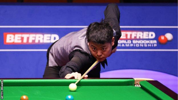 Liang Wenbo plays a shot