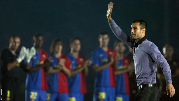 Pep Guardiola waves while the Barcelona squad applaud in the background