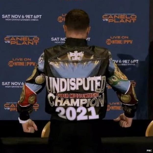 Saul 'Canelo' Alvarez poses in a coat which reads 'Undisputed' on the back