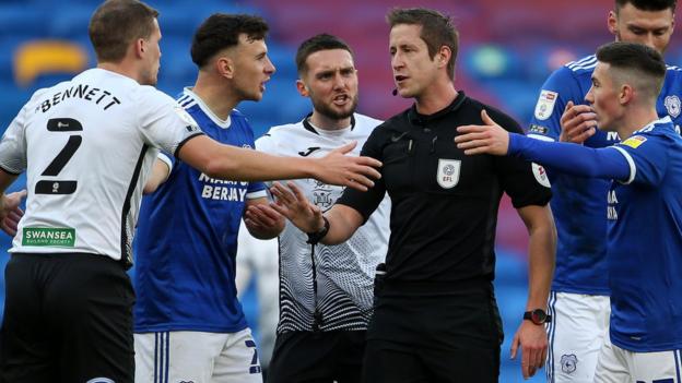 Referee John Brooks is surrounded by players during the south Wales derby between Swansea City and Cardiff City in December 2020