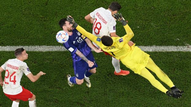 A diving Poland keeper Wojciech Szczesny makes contact with the face of Argentina's Lionel Messi