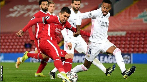 Real Madri's Eder Militao challenges Liverpool's Roberto Firmino