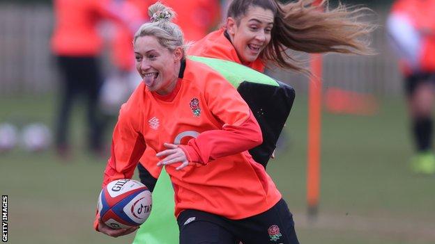 Natasha Hunt smiles while running with the ball