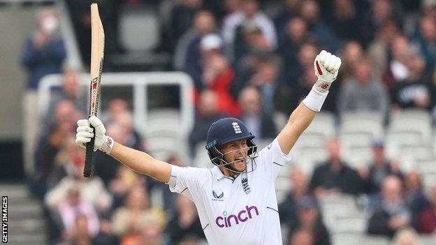 Joe Root raises his arms to celebrate victory over New Zealand