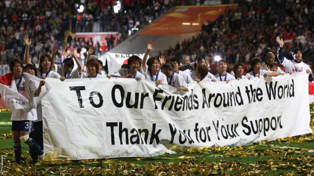 Japan's players hold up a banner after winning the 2011 Women's World Cup