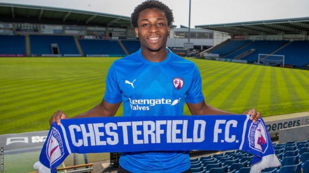 Winger Jesurun Uchegbulam holds a Chesterfield scarf after signing for the club