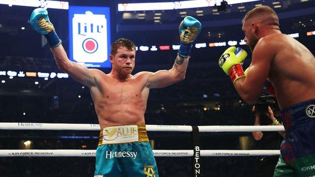 Alvarez raises his hands in front of Saunders seconds after landing the decisive uppercut