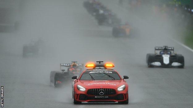 The safety car leads the drivers out around the track at Spa in the wet conditions