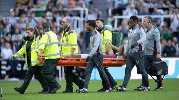 Tyrone Mings being carried off on a stretcher at St James' Park