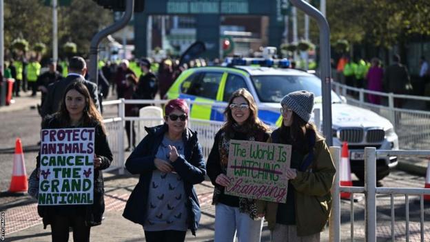 Protestors hold placards outside Aintree on Saturday morning