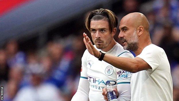 Manchester City manager Pep Guardiola speaks to Jack Grealish as he comes off the bench