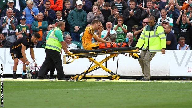 Mickey Demetriou of Newport County leaves the field on a stretcher against Plymouth