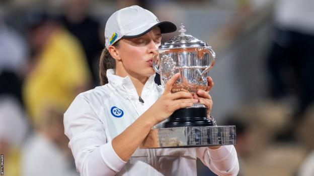 Iga Swiatek kisses the French Open trophy in 2022