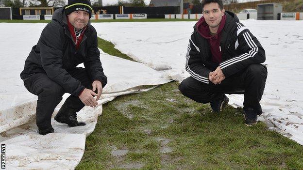 Carrick official Michael Hughes and referee Ian McNabb on the waterlogged pitch which led to the Shield semi-final with Linfield being called off