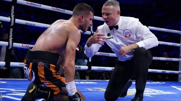 Connor Coghill, down on one knee, is given a count by the referee Bob Williams